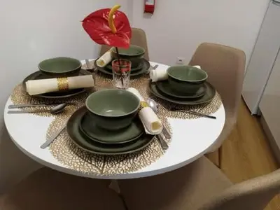 a table with green plates and utensils on it at Vivenda Silva in Seixal