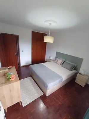 a bedroom with a large bed and a table at Village Green House Funchal in Funchal