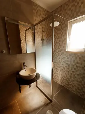 a bathroom with a sink and a glass shower at Village Green House Funchal in Funchal