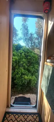 a window in a train with a view of a bush at Pauls Mobile Home in Baro de So Joo, Portugal in Barão de São João
