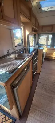 a kitchen in an rv with a sink and stove at Pauls Mobile Home in Baro de So Joo, Portugal in Barão de São João
