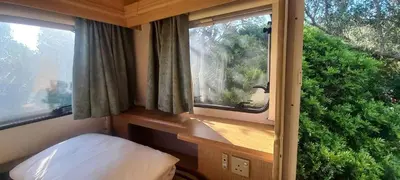 a small room with two windows and a bed in it at Pauls Mobile Home in Baro de So Joo, Portugal in Barão de São João