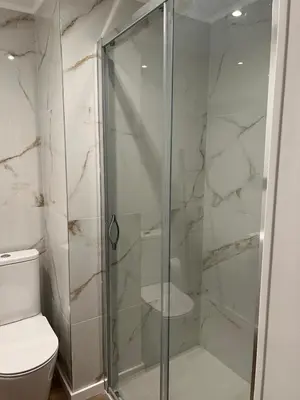 a glass shower in a bathroom with a toilet at Sè Urban Suite 21 in Funchal