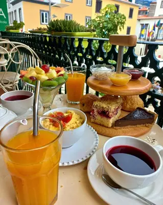 a table topped with plates of food and drinks at Sè Urban Suite 21 in Funchal