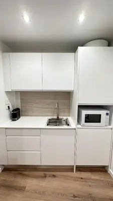 a white kitchen with a sink and a microwave at Sè Urban Suite 21 in Funchal