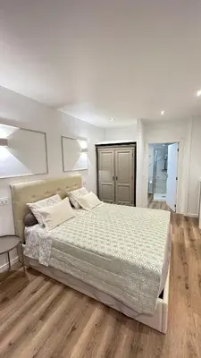 a bedroom with a large bed and a wooden floor at Se Urban Suite 22 in Funchal