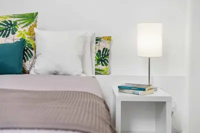 a bedroom with a bed and a table with a lamp at Funchal Tropical - Filodendro by Homie in Funchal