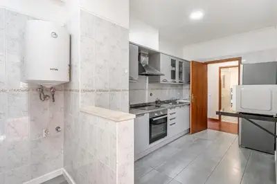 a white kitchen with a sink and a stove at Emerald Scape Garajau Madeira by GRM in Caniço