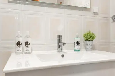 a white kitchen with a sink and a stove at Emerald Scape Garajau Madeira by GRM in Caniço