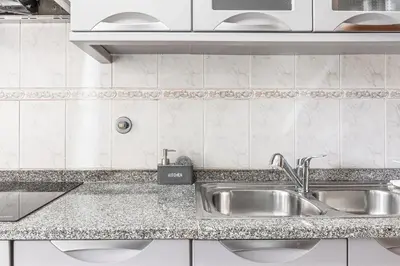 a kitchen with a sink and a counter top at Emerald Scape Garajau Madeira by GRM in Caniço