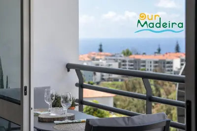 a balcony with two wine glasses on a table at OurMadeira - Alamos UpTown in Funchal
