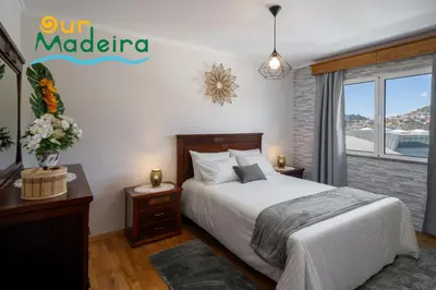 a bedroom with a bed and a large window at OurMadeira - Alamos UpTown in Funchal