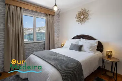 a bedroom with a large bed and a window at OurMadeira - Alamos UpTown in Funchal