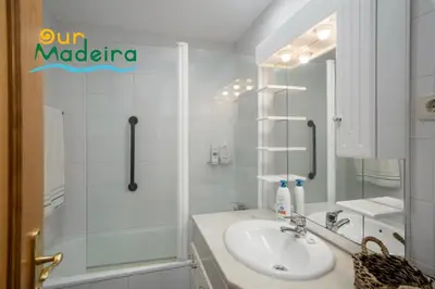 a white bathroom with a shower and a sink at OurMadeira - Alamos UpTown in Funchal