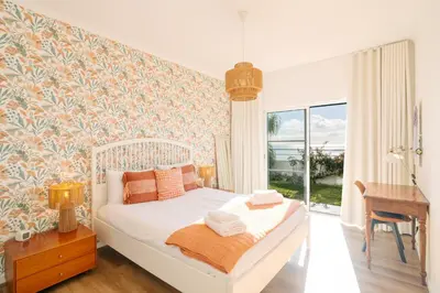 a bedroom with a bed and a desk and a window at Sunrise House by Wanderlust Madeira - 2 Bedroom Sea View in Gaula