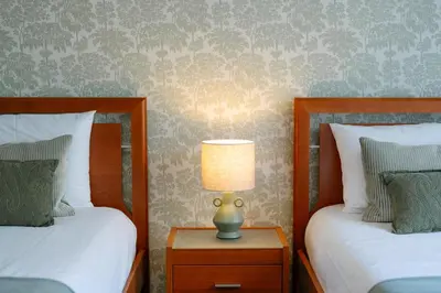 a bedroom with two beds and a lamp on a night stand at Sunrise House by Wanderlust Madeira - 2 Bedroom Sea View in Gaula