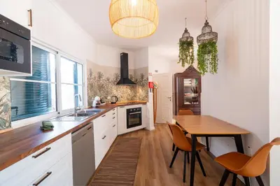 a kitchen with a wooden table and a dining room at Sunrise House by Wanderlust Madeira - 2 Bedroom Sea View in Gaula