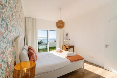 a bedroom with a bed and a large window at Sunrise House by Wanderlust Madeira - 2 Bedroom Sea View in Gaula