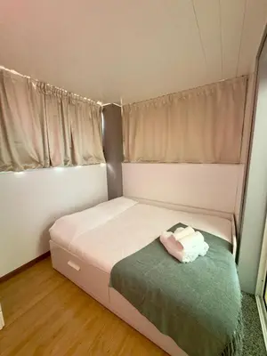 a small bedroom with a bed with a green blanket at Cantinho da Flor in Relógio do Poiso