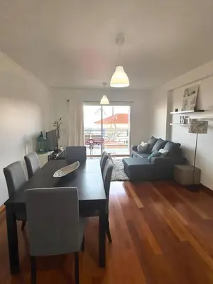 a living room with a table and a couch at Cantinho da Flor in Relógio do Poiso