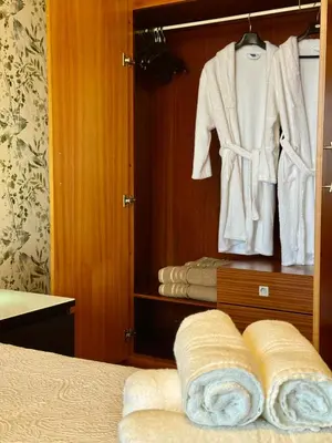 a room with a closet with a robe and towels at Cantinho da Flor in Relógio do Poiso