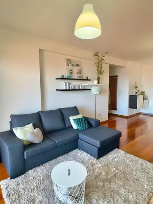 a living room with a blue couch and a table at Cantinho da Flor in Relógio do Poiso