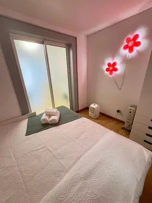 a bedroom with a white bed and a window at Cantinho da Flor in Relógio do Poiso