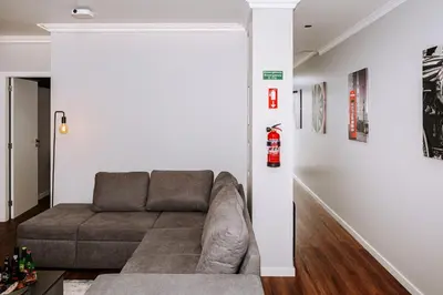 a living room with a couch against a white wall at Dark Yellow in Ponta do Sol