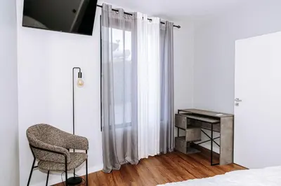 a bedroom with a chair and a desk at Dark Yellow in Ponta do Sol
