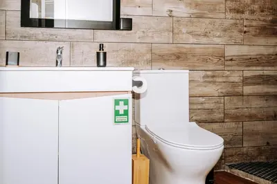 a bathroom with a white toilet and a sink at Dark Yellow in Ponta do Sol