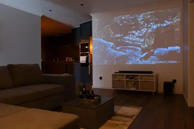 a living room with a large projection screen on the wall at Dark Yellow in Ponta do Sol