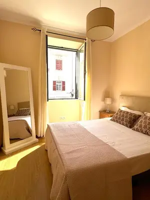 a bedroom with a large bed and a large mirror at Apartmento Centro Funchal in Funchal