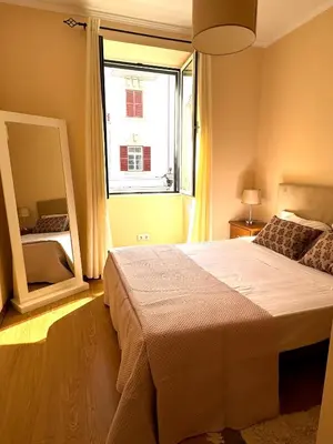 a bedroom with a large bed and a large window at Apartmento Centro Funchal in Funchal