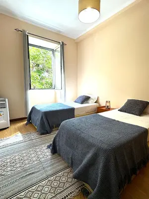 a bedroom with two beds and a window at Apartmento Centro Funchal in Funchal