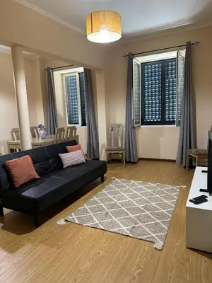 a living room with a black couch and a rug at Apartmento Centro Funchal in Funchal