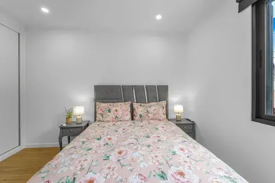 a bed with a pink floral pillow and a lamp at Casa da Guida in Machico