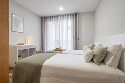 a bedroom with a large white bed and a window at Casa das Raposinhas VI, Funchal in Funchal