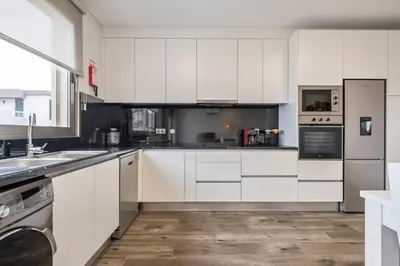 a kitchen with white cabinets and a sink at Casa das Raposinhas VI, Funchal in Funchal