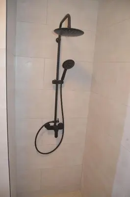 a shower with a black shower head in a bathroom at Vista dos Encantos in Machico