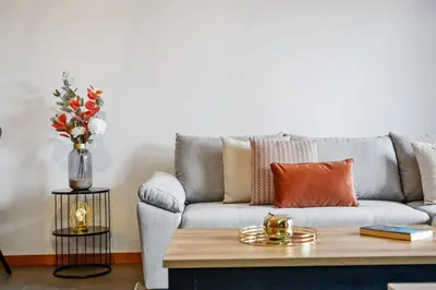 a living room with a grey couch with a vase of flowers at Urban Stay 1A by Homie in Funchal