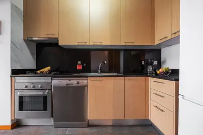 a kitchen with stainless steel appliances and wooden cabinets at Urban Stay 1A by Homie in Funchal