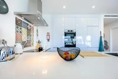 a white kitchen with a bowl on a counter at Paraíso Florido by the sea in Luz
