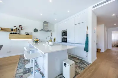 a white kitchen with a sink and a counter at Paraíso Florido by the sea in Luz