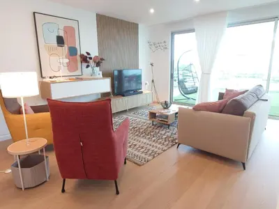 a living room with a couch and a chair at Paraíso Florido by the sea in Luz