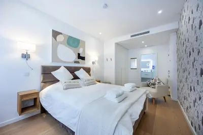 a bedroom with a large bed with white sheets and pillows at Paraíso Florido by the sea in Luz