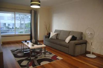 a living room with a couch and a table at Aurora Park com piscina in Funchal