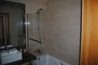 a bathroom with a shower and a tub and a sink at Aurora Park com piscina in Funchal