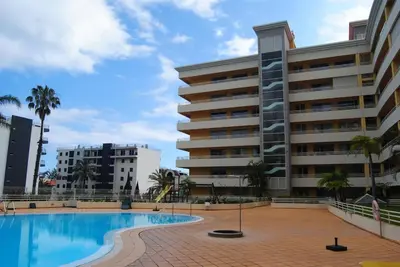 a swimming pool in front of a building at Aurora Park com piscina in Funchal