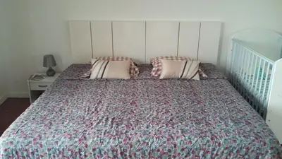 a bed with two pillows and a crib in a bedroom at Vista Funchal in Funchal