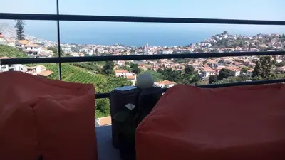 a room with two chairs and a view of a city at Vista Funchal in Funchal